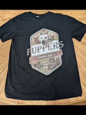Puppers Premium Lager Black Graphic Tee. Letterkenny
